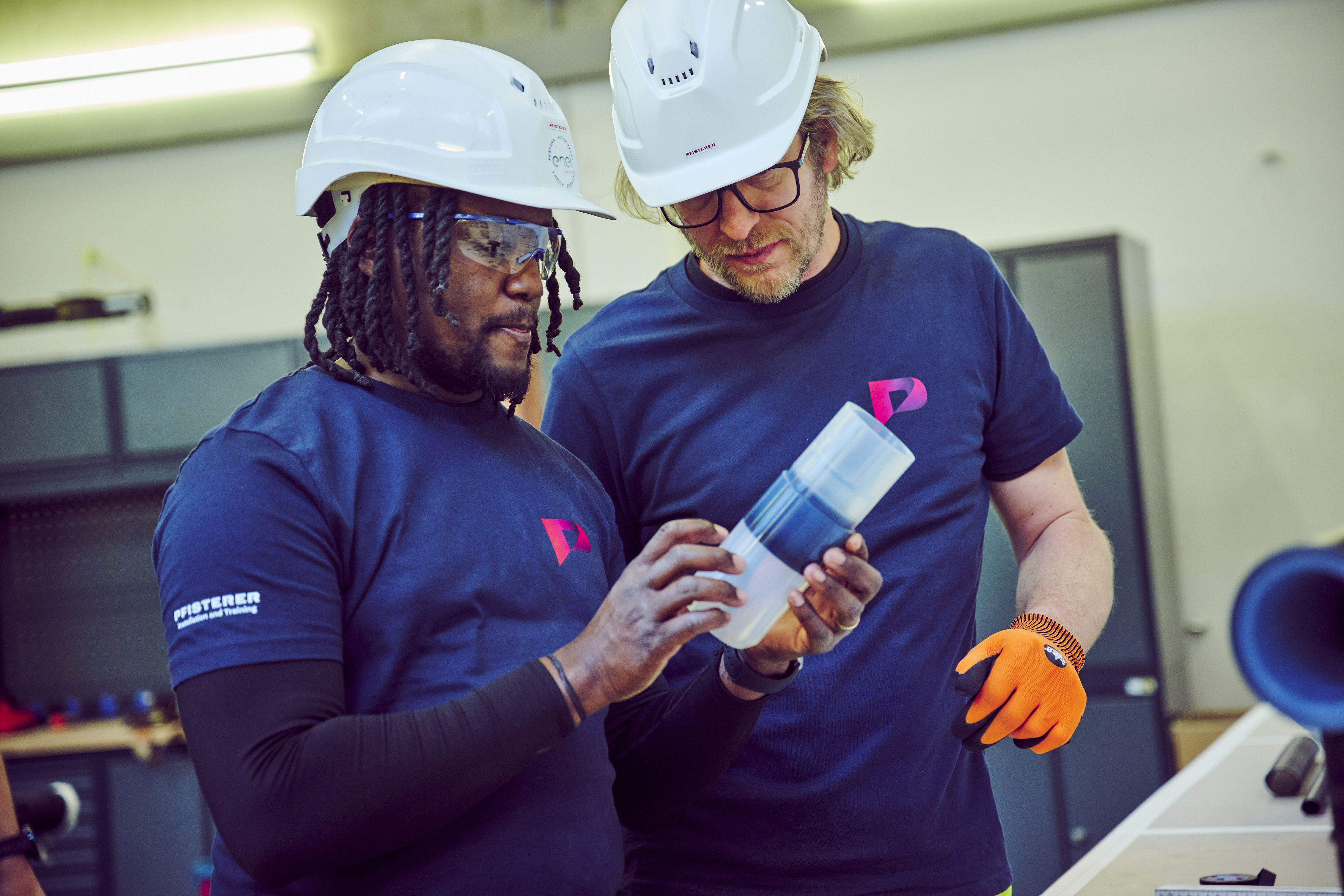 Zwei Monteure, die ein Isolierteil aus Silikon prüfen